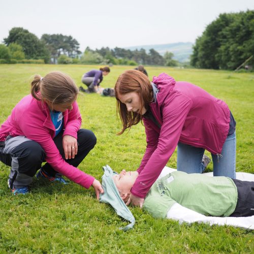 2 adults performing first aid