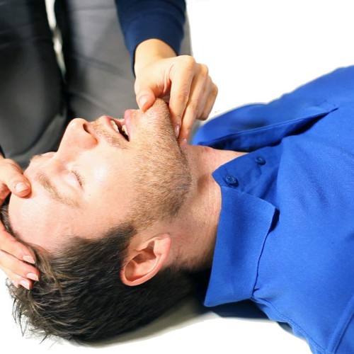 Adult performing first aid on a course