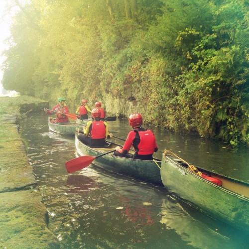 Pupils canoeing along a river