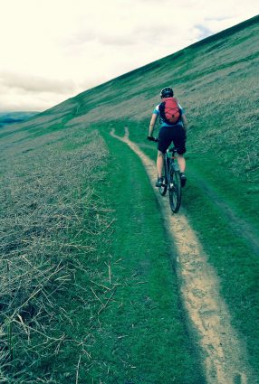 An adult biking along a track