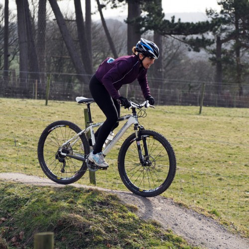 A women mountain biking on the bike trails and pump track at Thornbridge Outdoors