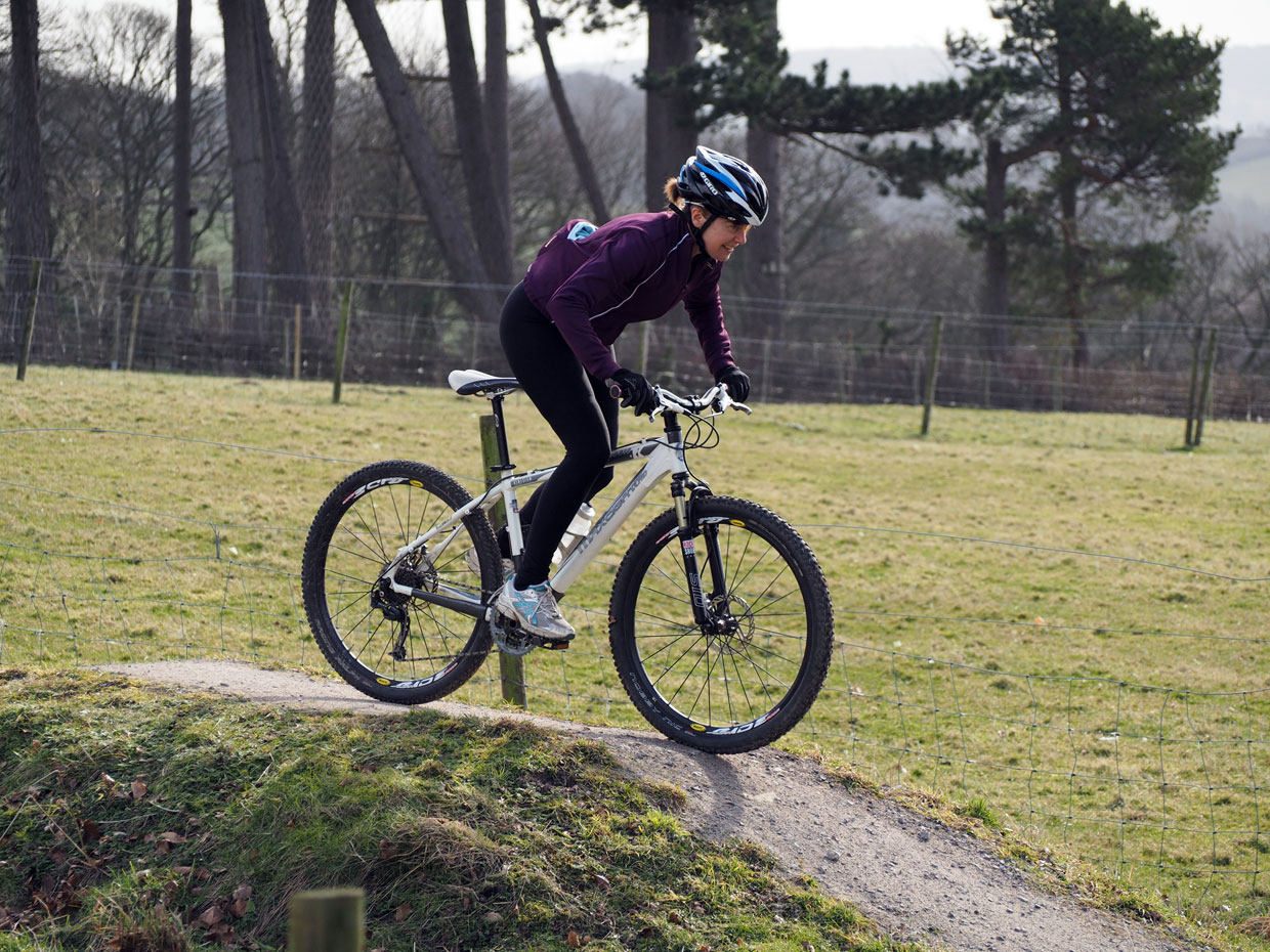 A women mountain biking on the bike trails and pump track at Thornbridge Outdoors