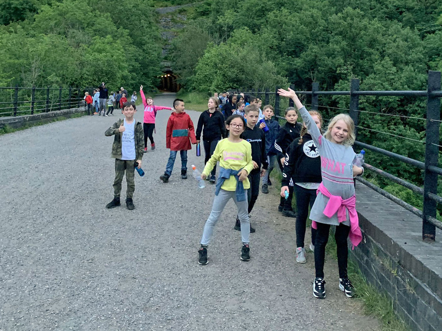 School children wave and smile for the camera as they stroll along the viaduct