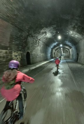 Children ride bikes in a tunnel on the Monsal Trail