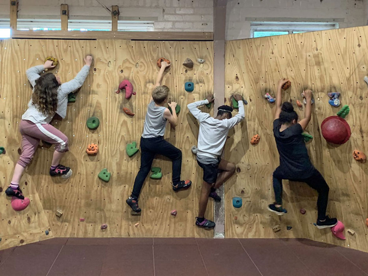 Children climb the indoor bouldering wall